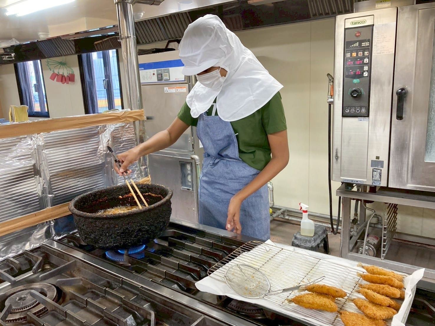 病院の給食室で調理する外国人スタッフ